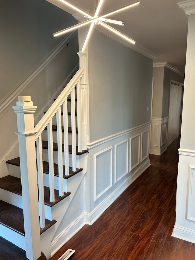 stairway with crown molding and wood-type flooring