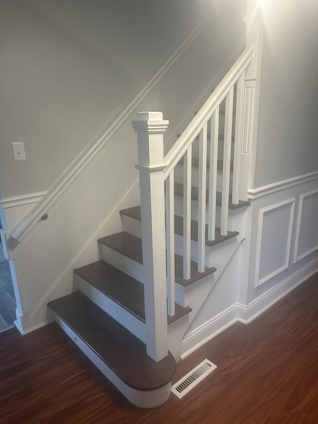 stairway featuring hardwood / wood-style floors and crown molding