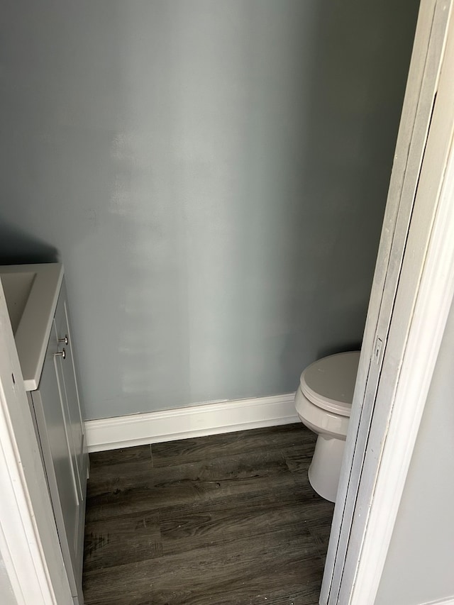 bathroom with toilet, hardwood / wood-style flooring, and vanity