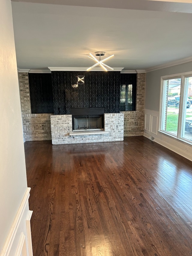 unfurnished living room featuring crown molding and dark wood-type flooring