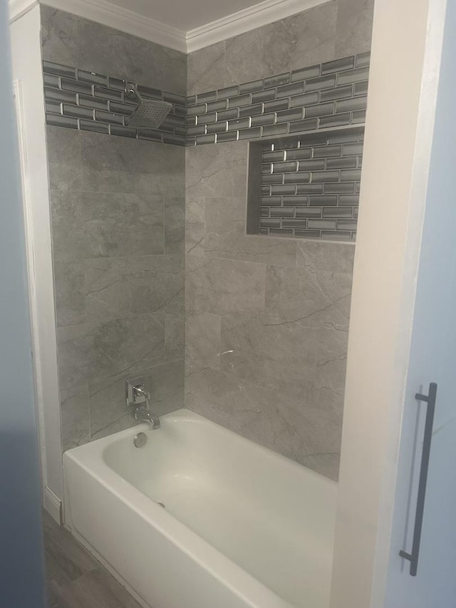 bathroom featuring crown molding and tiled shower / bath combo