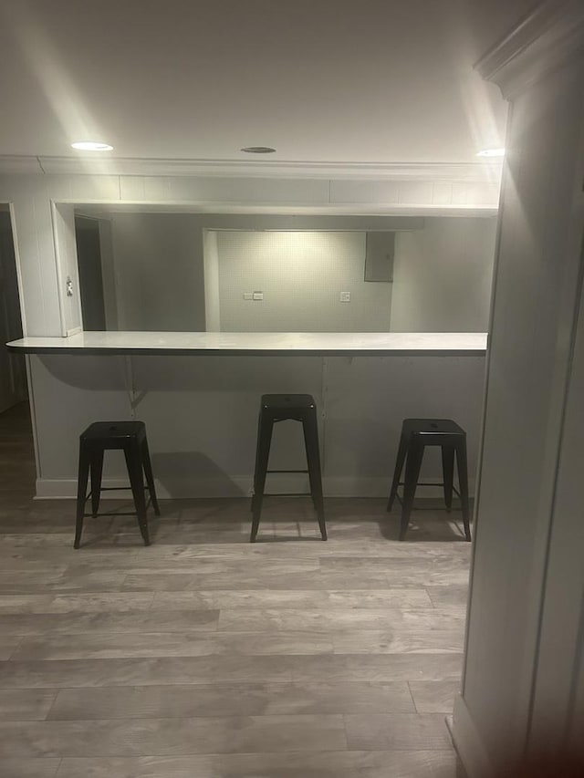 kitchen with a kitchen bar, kitchen peninsula, and light wood-type flooring