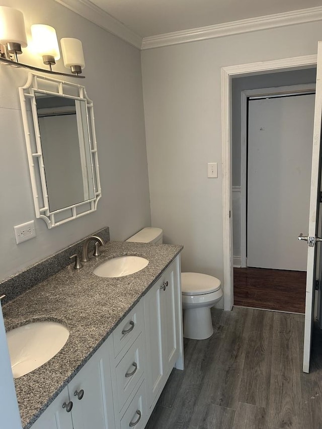 bathroom featuring crown molding, wood-type flooring, toilet, and vanity