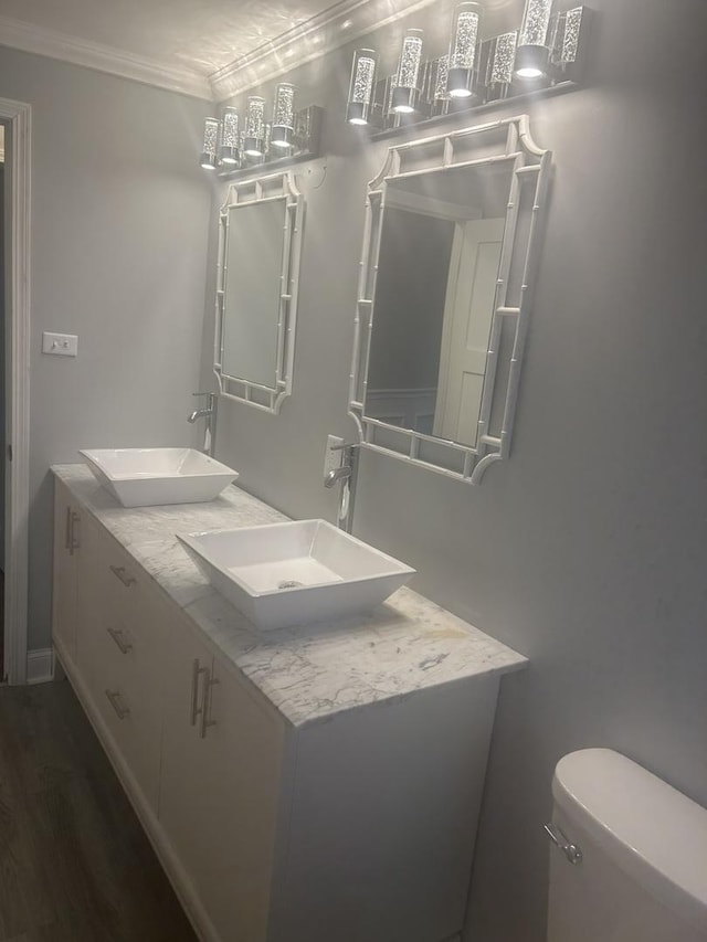 bathroom with vanity, hardwood / wood-style floors, crown molding, and toilet