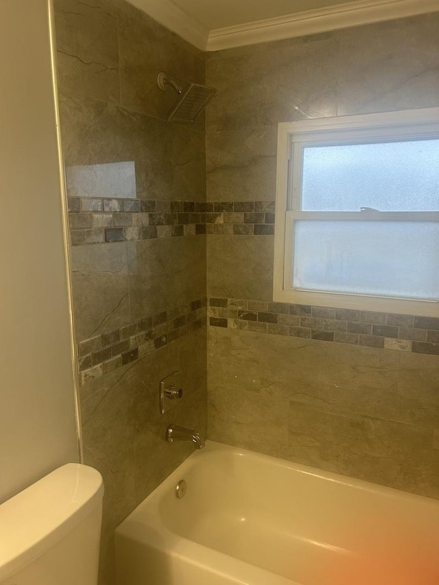 bathroom featuring tiled shower / bath, crown molding, and toilet