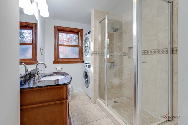 bathroom featuring vanity, stacked washer / drying machine, a shower with shower door, and tile patterned floors