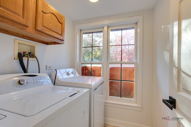 laundry room featuring washing machine and dryer and cabinets