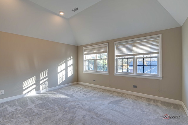 empty room featuring light carpet and high vaulted ceiling