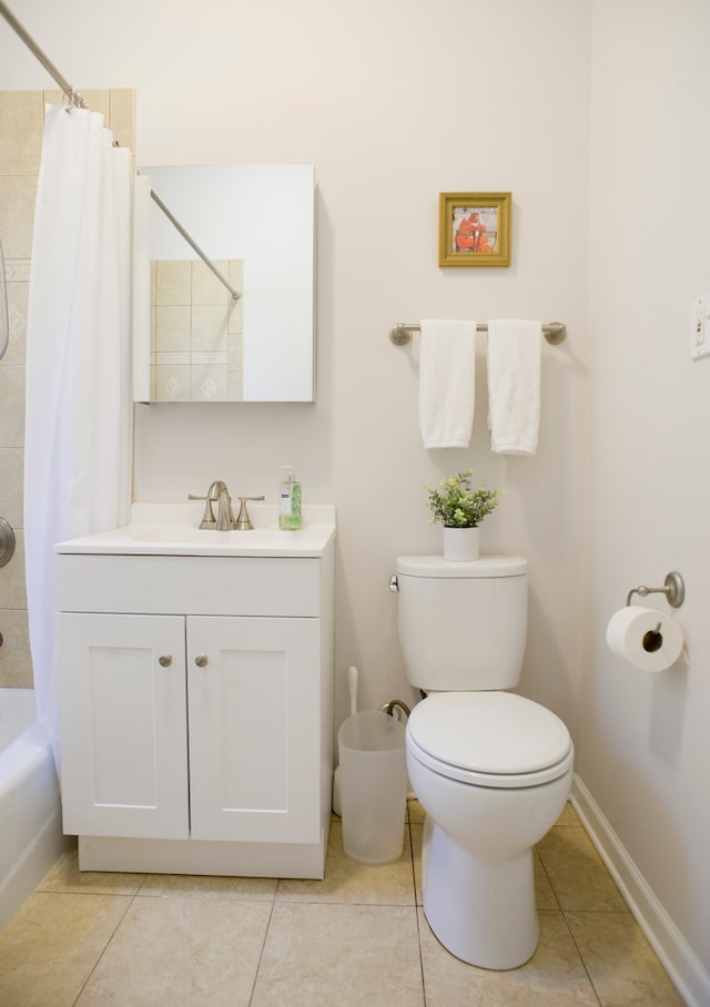 full bathroom with tile patterned flooring, vanity, toilet, and shower / bath combo with shower curtain