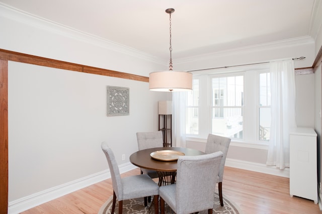 dining room with ornamental molding and light wood-type flooring