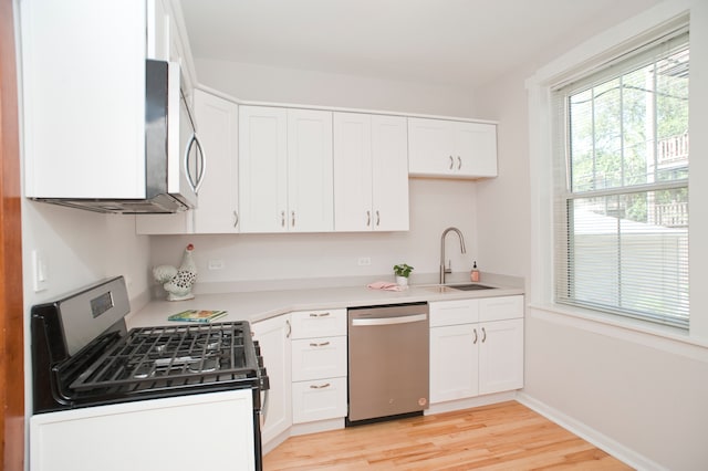 kitchen featuring sink, white cabinetry, stainless steel appliances, and light wood-type flooring