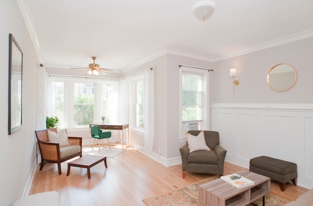 living area with light wood-type flooring, ceiling fan, and crown molding