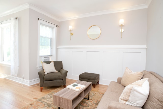 living room with light wood-type flooring and ornamental molding