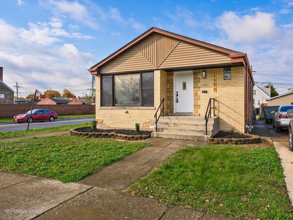 bungalow-style home with a front lawn