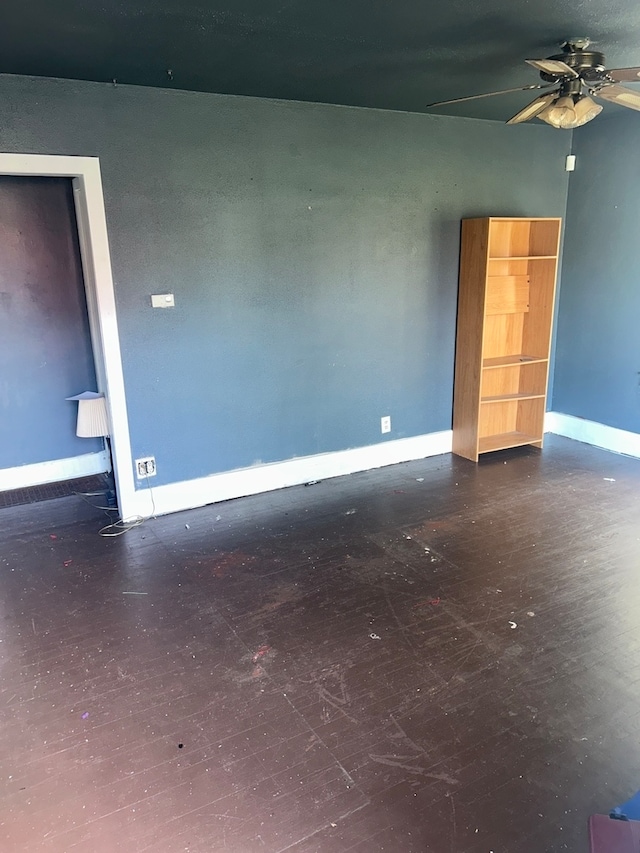 unfurnished room featuring dark wood-type flooring and ceiling fan