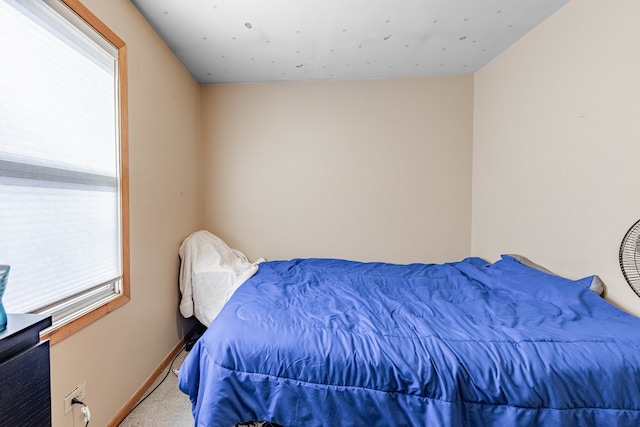 carpeted bedroom featuring multiple windows