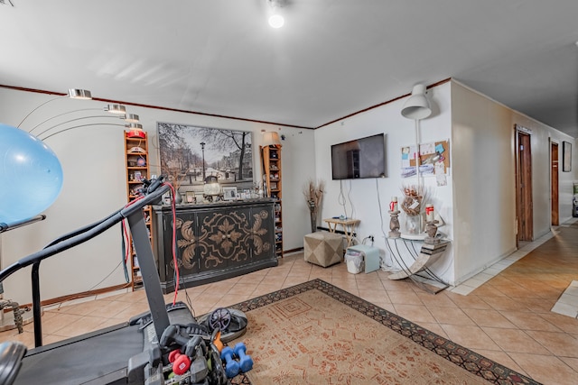 workout area with crown molding and tile patterned flooring