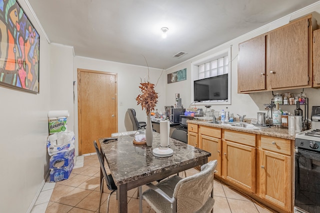 kitchen featuring light tile patterned flooring, crown molding, range, and sink