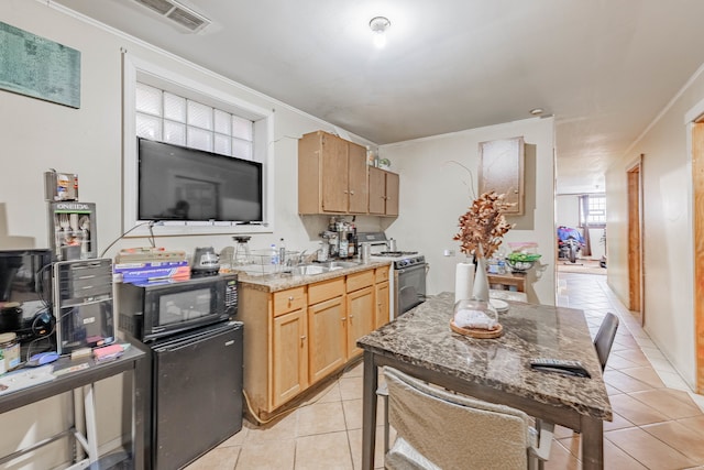 kitchen featuring stainless steel gas stove, sink, crown molding, light tile patterned floors, and light stone counters