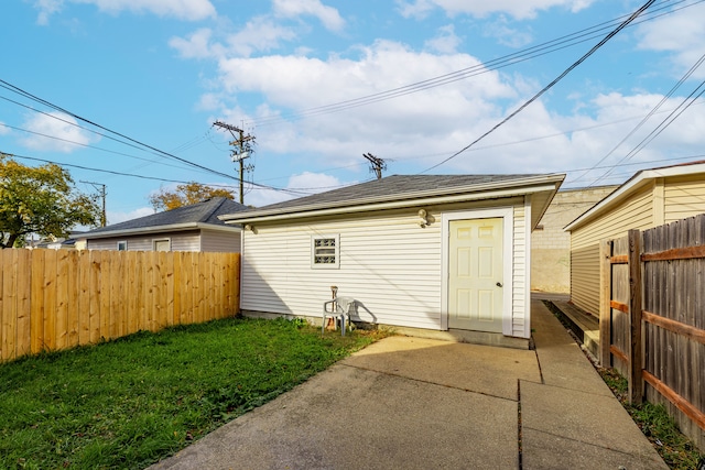 rear view of property with a yard, a patio area, and an outdoor structure