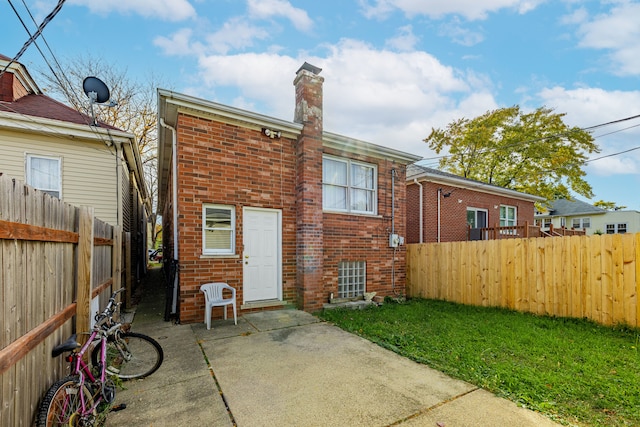 back of house featuring a patio and a lawn