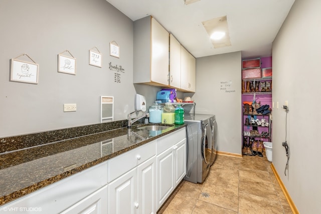 washroom with sink, washer and dryer, light tile patterned floors, and cabinets