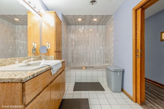 bathroom featuring vanity, a relaxing tiled tub, toilet, and tile patterned flooring