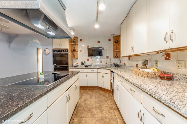 kitchen featuring white cabinets, tasteful backsplash, and black appliances