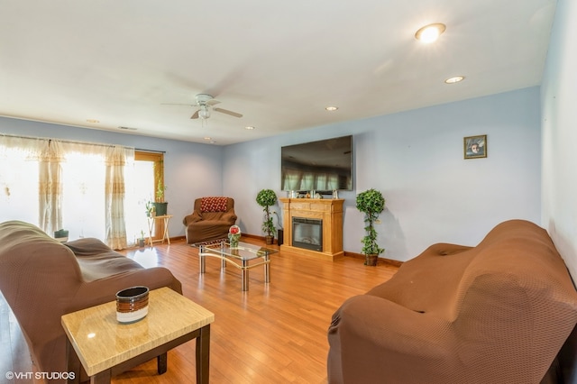 living room featuring light hardwood / wood-style flooring and ceiling fan