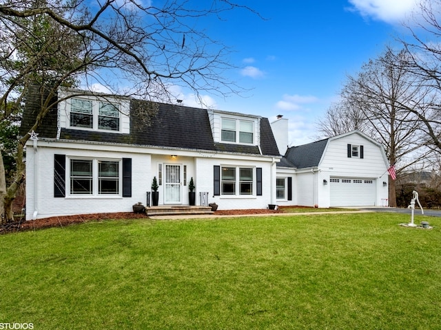 new england style home with a front yard and a garage