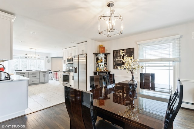 dining space with light hardwood / wood-style floors, a chandelier, and a wealth of natural light