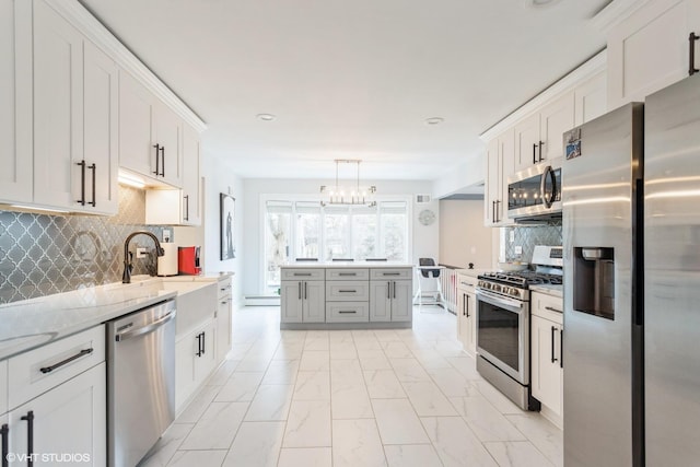 6430 Thurlow St, Willowbrook, IL 60527 - kitchen with stainless steel appliances, a chandelier, light marble finish flooring, backsplash, and light stone counters