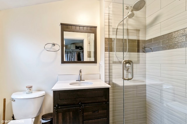 bathroom featuring vanity, toilet, and a shower with shower door