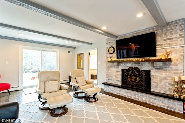 living area with beam ceiling, a brick fireplace, wood-type flooring, and baseboard heating