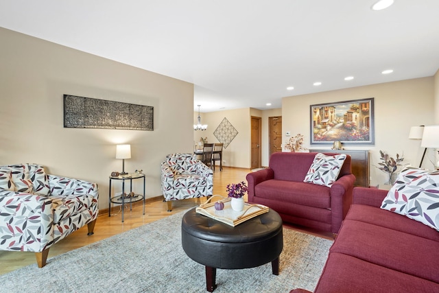 living room with an inviting chandelier and light wood-type flooring