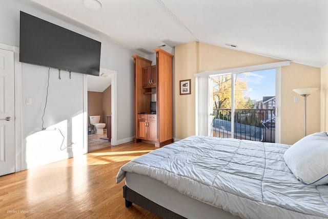 bedroom featuring access to exterior, vaulted ceiling, ensuite bathroom, and light wood-type flooring