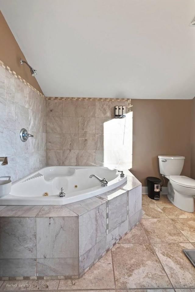 bathroom with toilet, lofted ceiling, and tiled bath