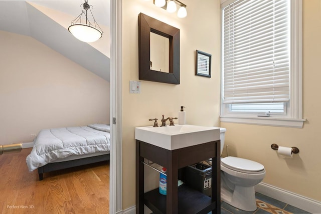 bathroom featuring lofted ceiling, sink, hardwood / wood-style floors, and toilet