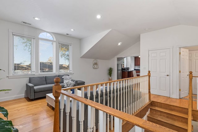 hall featuring vaulted ceiling and light hardwood / wood-style flooring