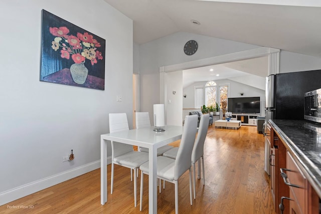 dining space featuring lofted ceiling and light wood-type flooring