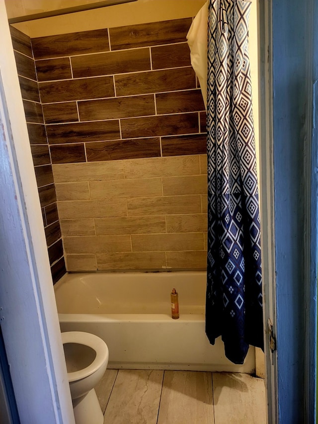 bathroom featuring shower / tub combo and toilet