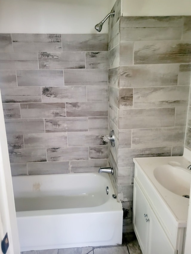 bathroom featuring vanity and tiled shower / bath