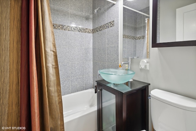 full bathroom featuring toilet, shower / bath combo with shower curtain, and vanity