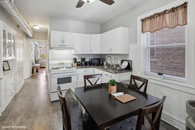 kitchen with white cabinets, ceiling fan, hardwood / wood-style flooring, gas range gas stove, and sink