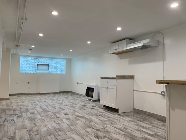 basement with heating unit and light hardwood / wood-style floors