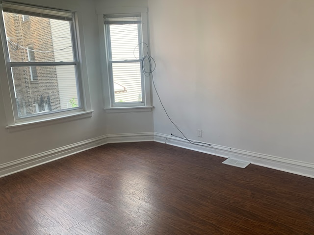 empty room featuring dark hardwood / wood-style floors and a wealth of natural light