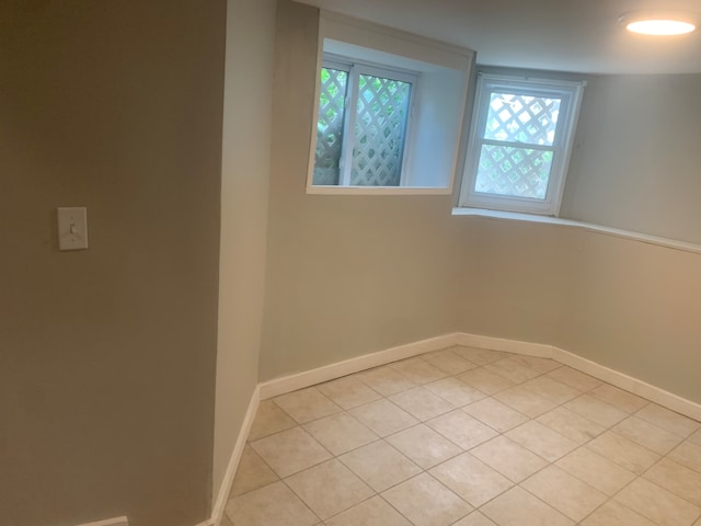 empty room featuring light tile patterned flooring and plenty of natural light