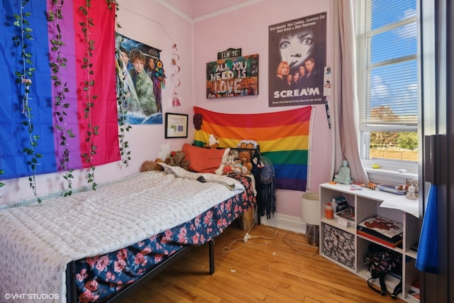 bedroom featuring ornamental molding and hardwood / wood-style flooring