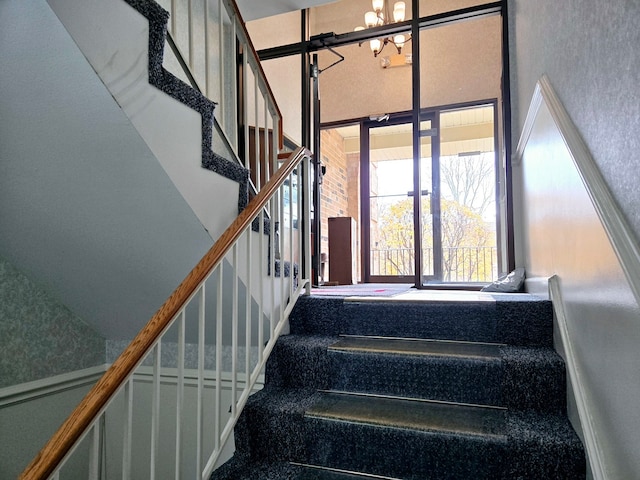 staircase featuring a chandelier