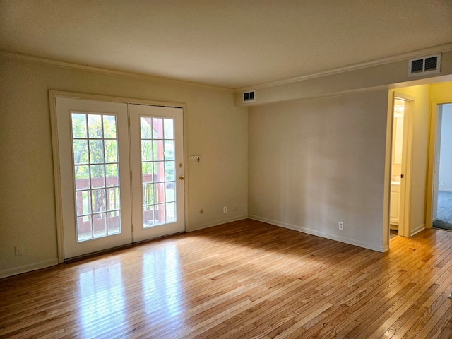 spare room with light hardwood / wood-style floors and crown molding